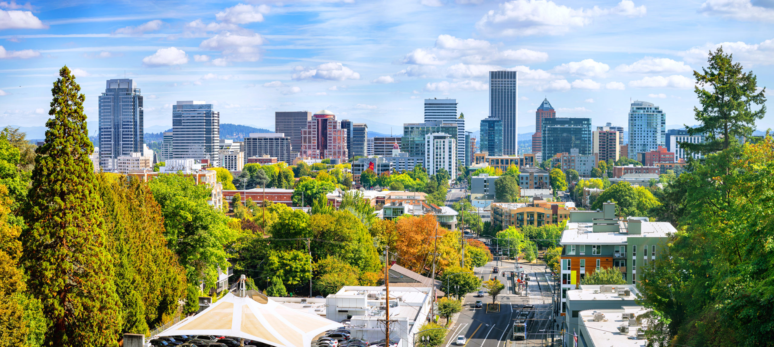 Classic panoramic view of famous Portland skyline with busy downtown scenery, colorful leaves and iconic Mount Hood in the background on a beautiful sunny day in fall, American Northwest, Oregon, USA